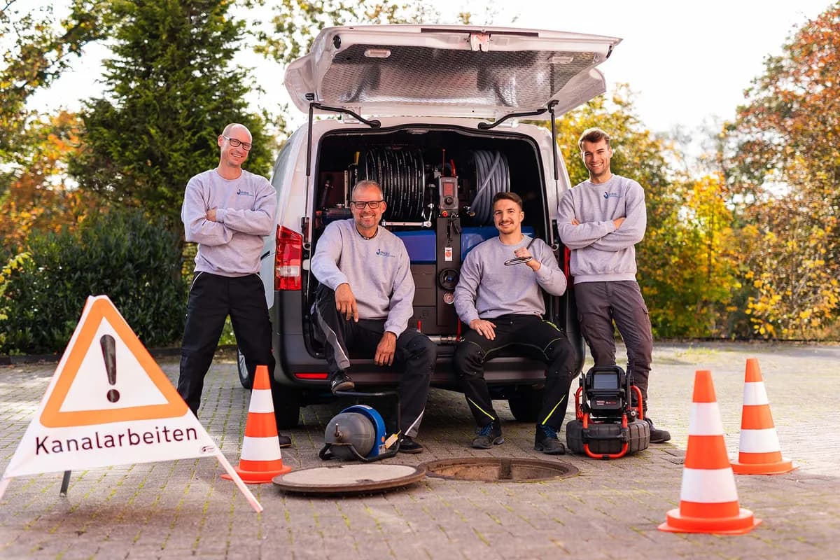 Team von Jakobs Rohrreinigung am geöffneten Einsatzfahrzeug